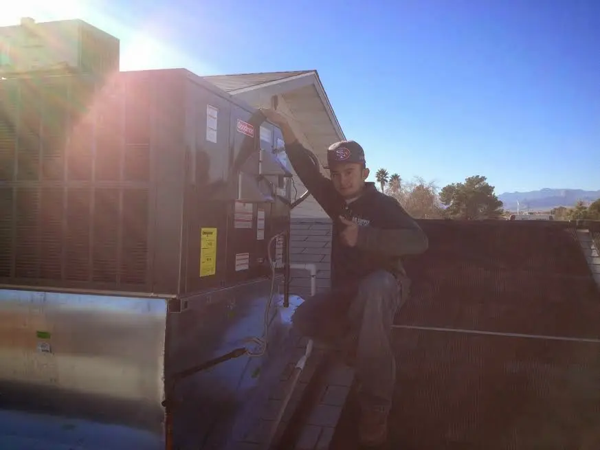 HVAC technician performing Heat Pump Repair on a rooftop unit in Castaic